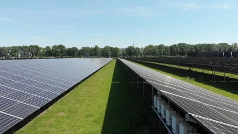 Rows of solar panels in large solar farm on sunny day, aerial truck reveal Stock Footage 131503181
