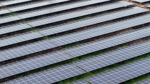 Rows of solar panels stretch across a grassy field Vidéo 344815873