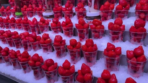 Rows of strawberries sit in clear cups on crushed ice at fruit market displ.. Stock Footage 344736841