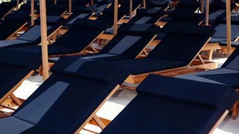 Rows of sunbeds under beach umbrellas at tropical resort Stock Photos