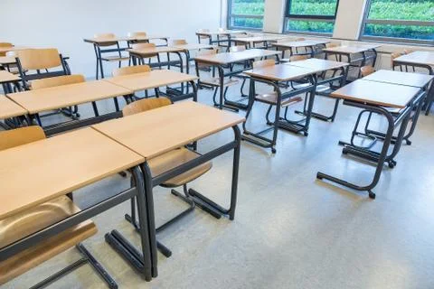 Rows of tables and chairs in classroom Stock Photos