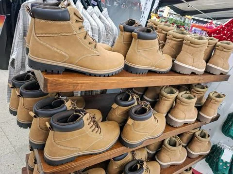 Rows of tan nubuck work boots with dark brown padded collars on display in .. Stock Photos