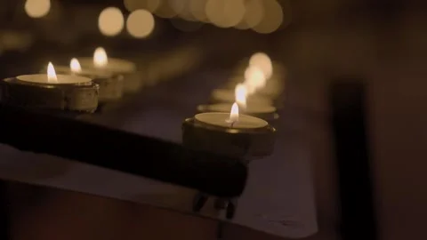Rows of tea light candles burning in offering rack focus in 4k Vidéo 305014942