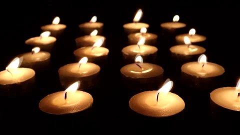 Rows of Tealigh Candles Being Blown Out With A Dark  black Background Video stock 132274683