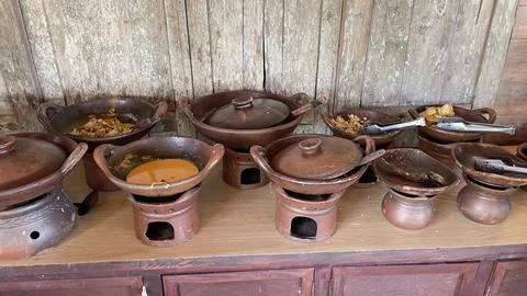 Rows of tiny antique clay cooking utensils on antique wooden tables  Stock Photos