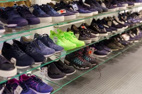 Rows upon rows of shoes on display inside a shoe store entice shoppers to f.. Stock-Fotos
