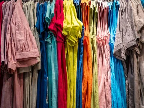 Rows of Vibrant Multi-Colored Linen Clothes Hanging in Store Stock Photos