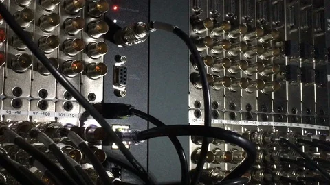 Rows of video SDI inputs and outputs in the back of a patch panel. Stock Footage 99596822