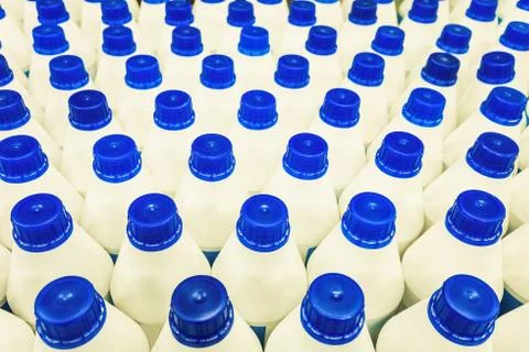 Rows of white bottles with blue plastic caps Stock Photos