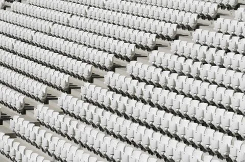 Rows of white empty plastic seats in a stadium Stock Photos