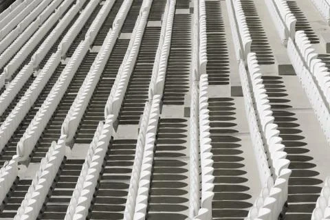 Rows of white empty plastic seats in a stadium Stock Photos