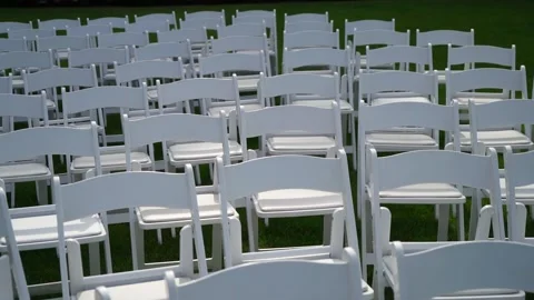 Rows of White Folding Chairs on Green Grass for Outdoor Event Stock Footage 290849215