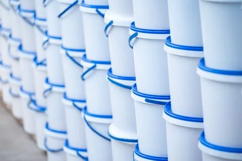 Rows of white plastic buckets with blue lids Stock Photos