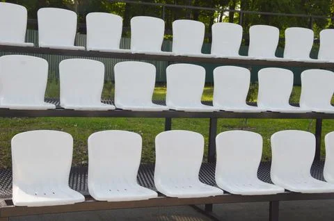 Rows of white plastic empty seats for fans of a sports stadium. Outdoor spo.. Stock Photos