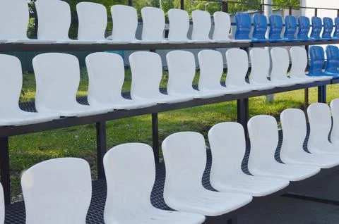 Rows of white plastic empty stadium seats. Sports facility. Stock Photos