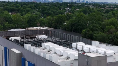Rows of white rooftop backup generators line large data center building in Stock Footage 340924895