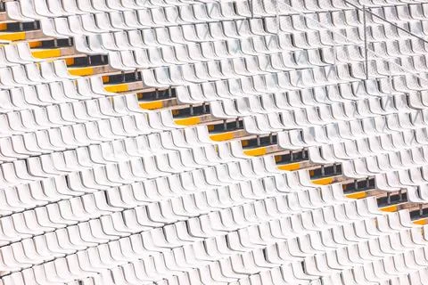 Rows of white stadium seats create a geometric pattern Stock Photos