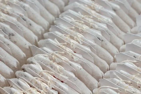 Rows of white tea bags with strings arranged in a neat pattern for brewing 스톡 사진