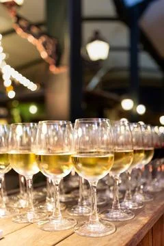 Rows of white wine glasses filled and ready for guests at a catered reception Stock Photos