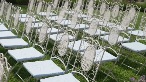 Rows Of White Wrought Iron Chairs On Grass Before An Outdoor Wedding Stock Footage 343803160