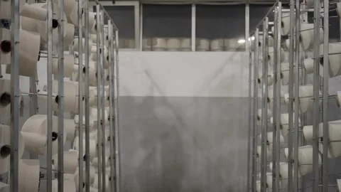 Rows of yarn spools stored on metal racks inside textile factory Stock Footage 327444902