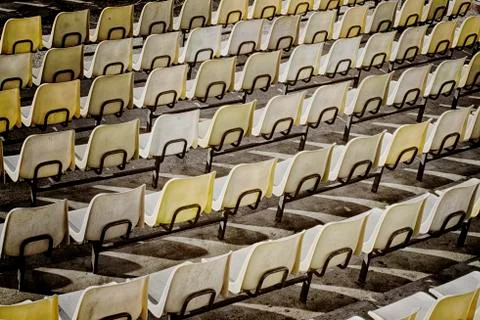 Rows of yellow plastic seats in open theater rear view Stock Photos