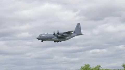 Royal Air Force C-130 Hercules flying low over UK countryside near Mildenhall Stock Footage 310772699