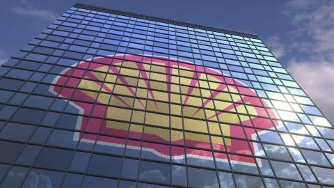 ROYAL DUTCH SHELL PLC logo on modern building reflecting sky and clouds Ilustración de archivo