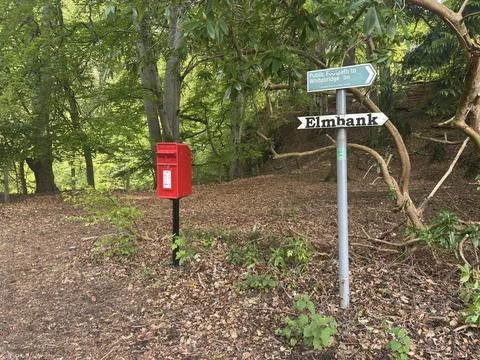 Royal Mail post box and rural sign post near woodland, Scottish countryside Stock Photos