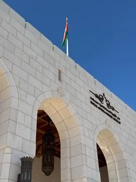 Royal Opera House Muscat front facade with arches and flag under clear blue sky Stock Photos