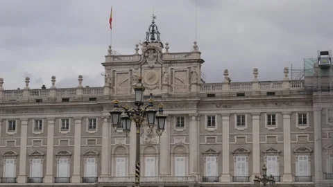 Royal Palace of Madrid central facade with clock and Spanish flag vertical pan Stock Footage 334962408