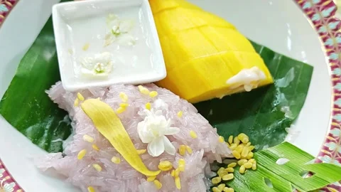 Royal Thai butterfly pea mango sticky rice served on a luxury Benjarong plate. Stock Footage 342404191