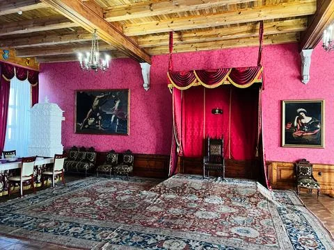 Royal throne room with red canopy, ornate carpet and antique paintings in a.. Stock Photos