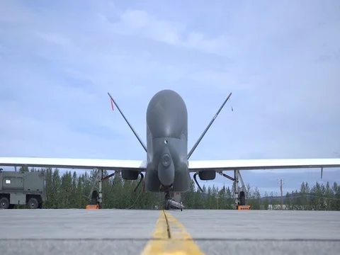 RQ-4 Global Hawk parked with wheel chocks and remove before flight tags in place Stock Footage 94328971