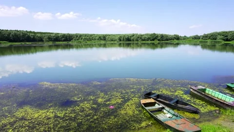 Rreflection of clouds on the river's surface and a small boats tied Stock Footage 258610425