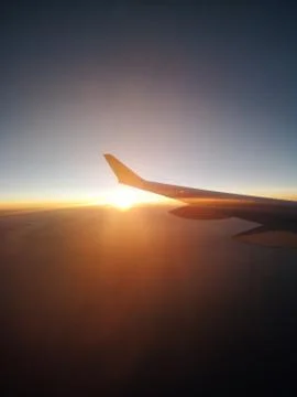 Rrem Sunset from a plain. View through the window of an aircraft. Wing of the Stock Photos