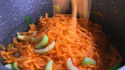 Rubbed carrot in the pot, cutted celery falling down on it Video stock 193007331