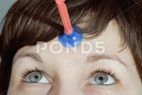 Rubber dart stuck to woman's forehead Stock Photos
