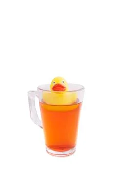 Rubber duck in a glass of hot tea isolated on a white background Stock Photos
