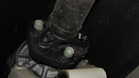 A rubber flexible coupling disc connecting a car driveshaft Stock Footage 343419251