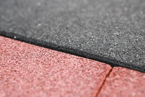 Rubber flooring is shown in a close-up view. The surface features alternating Stock Photos