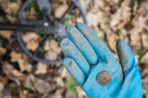 A rubber-gloved digger archaeologist found an expensive historical coin Stock Photos