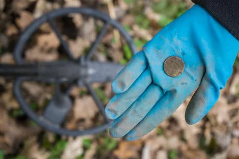 A rubber-gloved digger archaeologist found an expensive historical coin Stock Photos