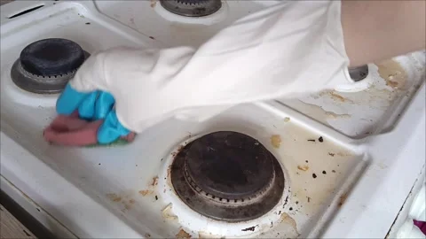 Rubber-gloved hands sponge the gas stove Stock Footage 311697230