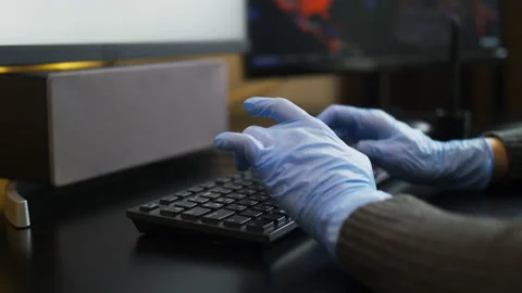 Rubber-gloved hands typing on eng-rus keyboard, prevent virus spreading Stock Footage 150027423