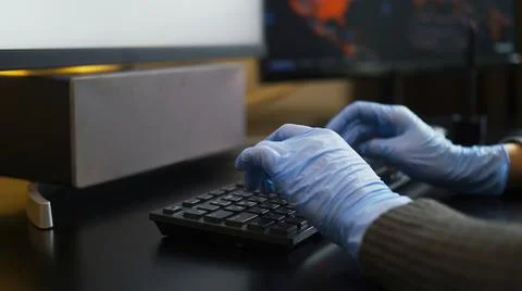 Rubber-gloved hands typing on eng-rus keyboard, prevent virus spreading Stock Photos