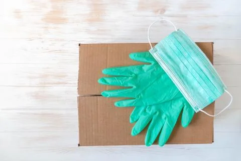 Rubber gloves and face protective mask on closed donation box Stock Photos