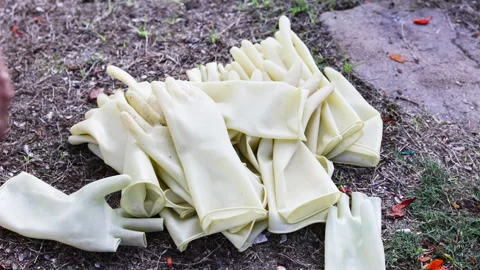 Rubber gloves lying on earth. Video stock 284424580