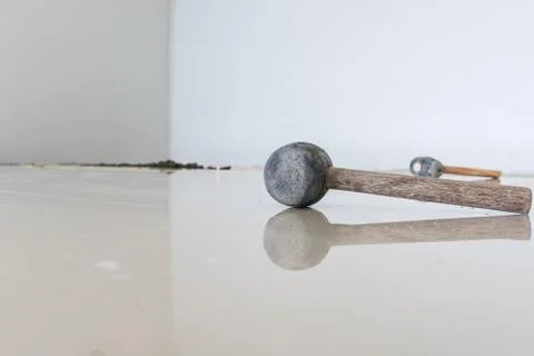 Rubber hammer on floor tile installation for house building Fotos Stock