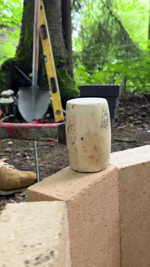 Rubber Mallet on Fire Bricks During DIY Fire Pit Construction Stock Footage 342001998